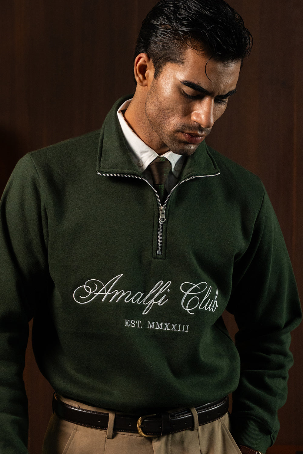 Close-up of Deep Forest Amalfi Quarter Zipper with Amalfi Club lettering, worn by a man