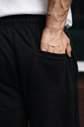 Close-up of black Pants highlighting back pocket and elastic waistband detail