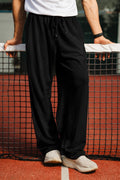 Man wearing black tapered fit Pants with drawstring waist on a tennis court

