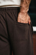 Close-up of dark brown Pants highlighting back pocket and elastic waistband detail