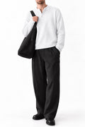 Man wearing IVAR white dropneedle full sleeve henley with black trousers
