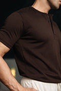 Close-up of man wearing dark brown Henley highlighting fabric texture and fit
