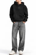 Man wearing the Black NYC Hoodie with grey jeans, front view