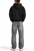 Man wearing the Black NYC Hoodie with grey jeans, back view
