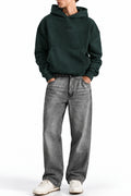 Man wearing the Deep Forest NYC Hoodie with grey jeans, front view