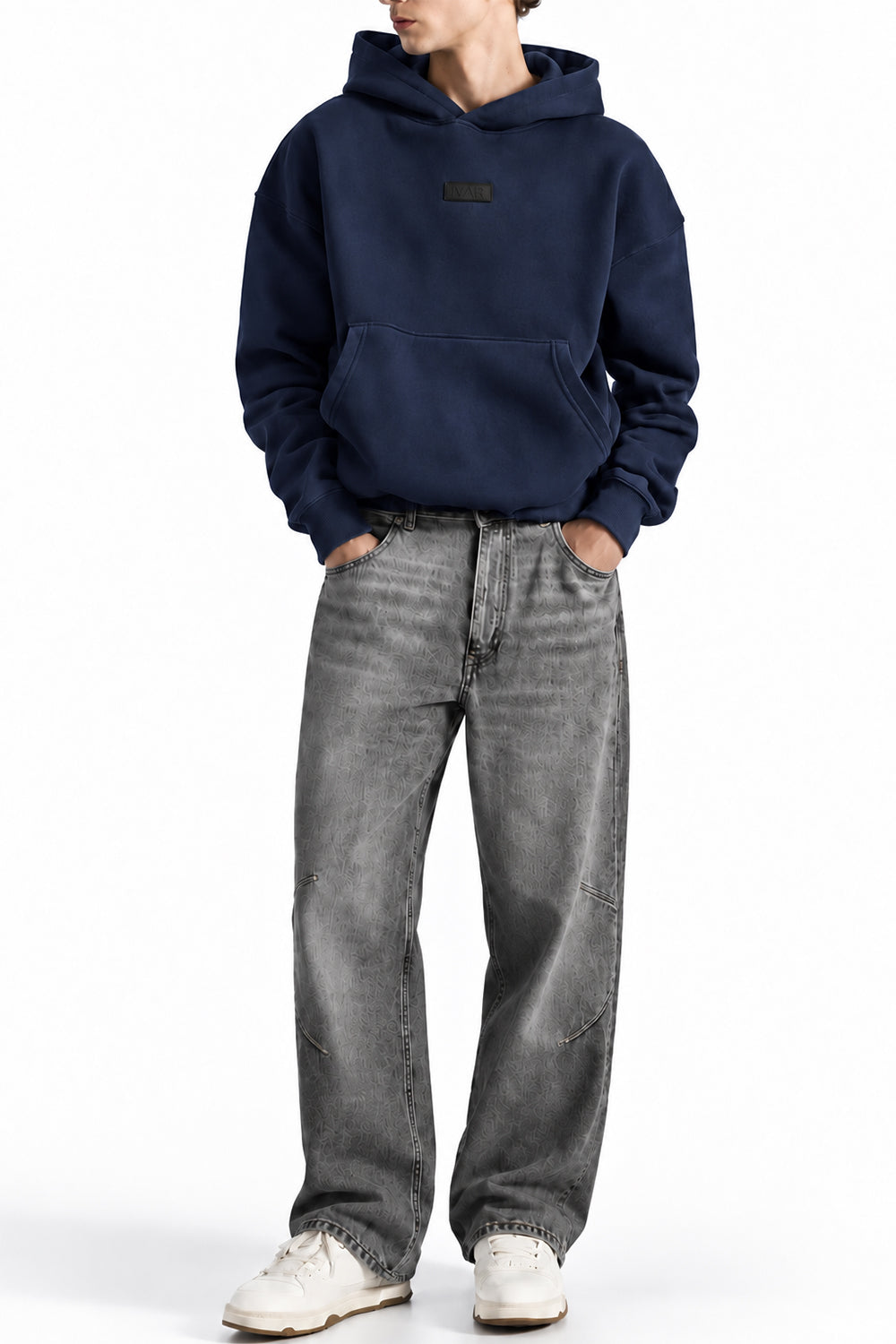 Man wearing the Navy NYC Hoodie with grey jeans, front view