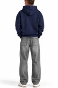 Man wearing the Navy NYC Hoodie with grey jeans, back view