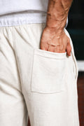 Close-up of off-white Pants highlighting back pocket and elastic waistband detail