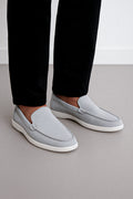 a person wearing grey Suede Loafers paired with tailored black trousers.