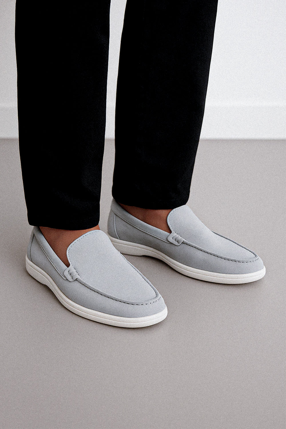 a person wearing grey Suede Loafers paired with tailored black trousers.